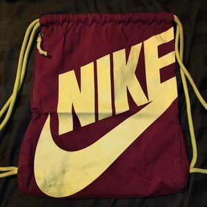 Nike drawstring gym bag with purple-ish pink color and yellow lettering
